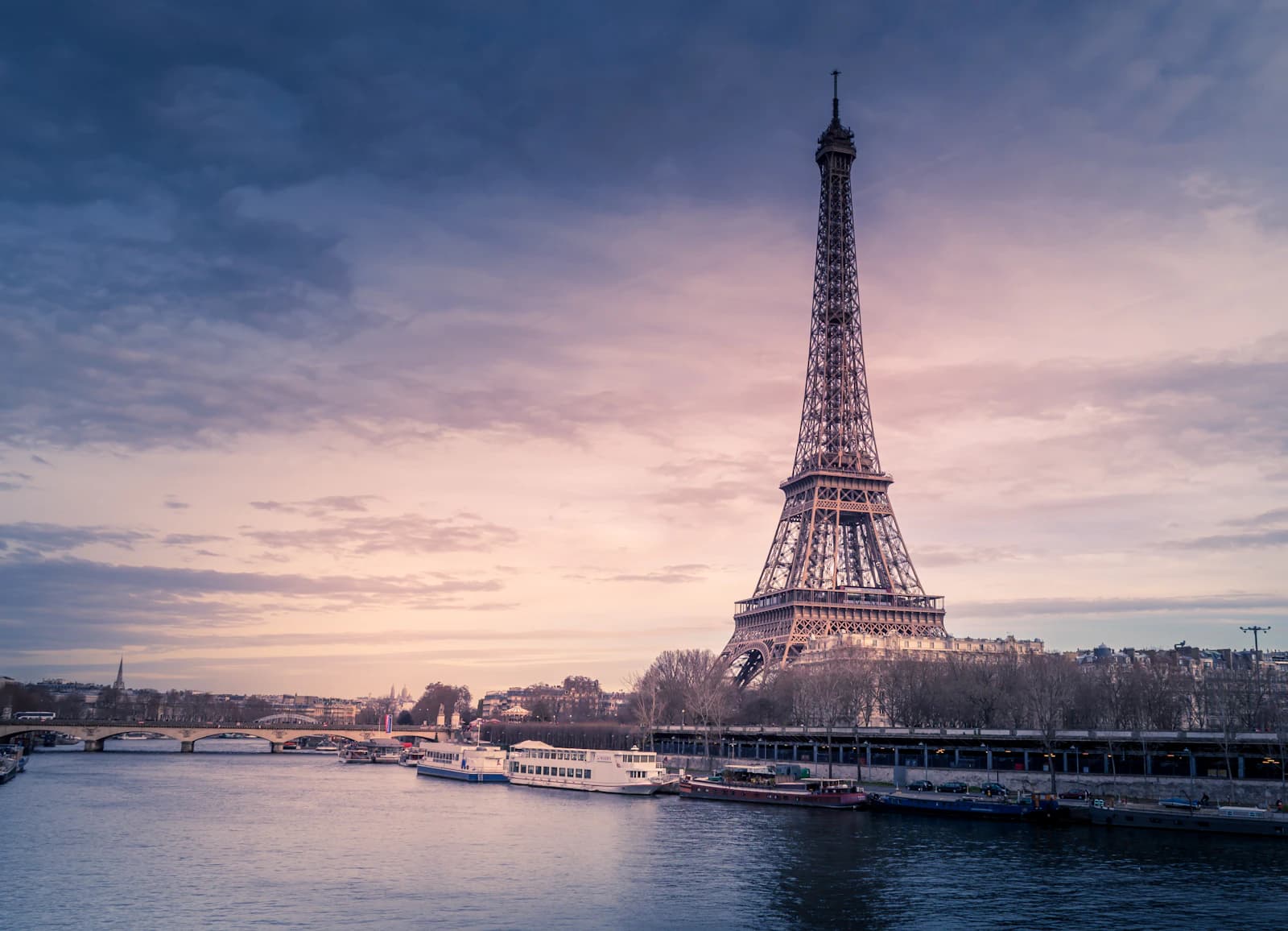 The Eiffel Tower beside the Seine at dusk in Paris