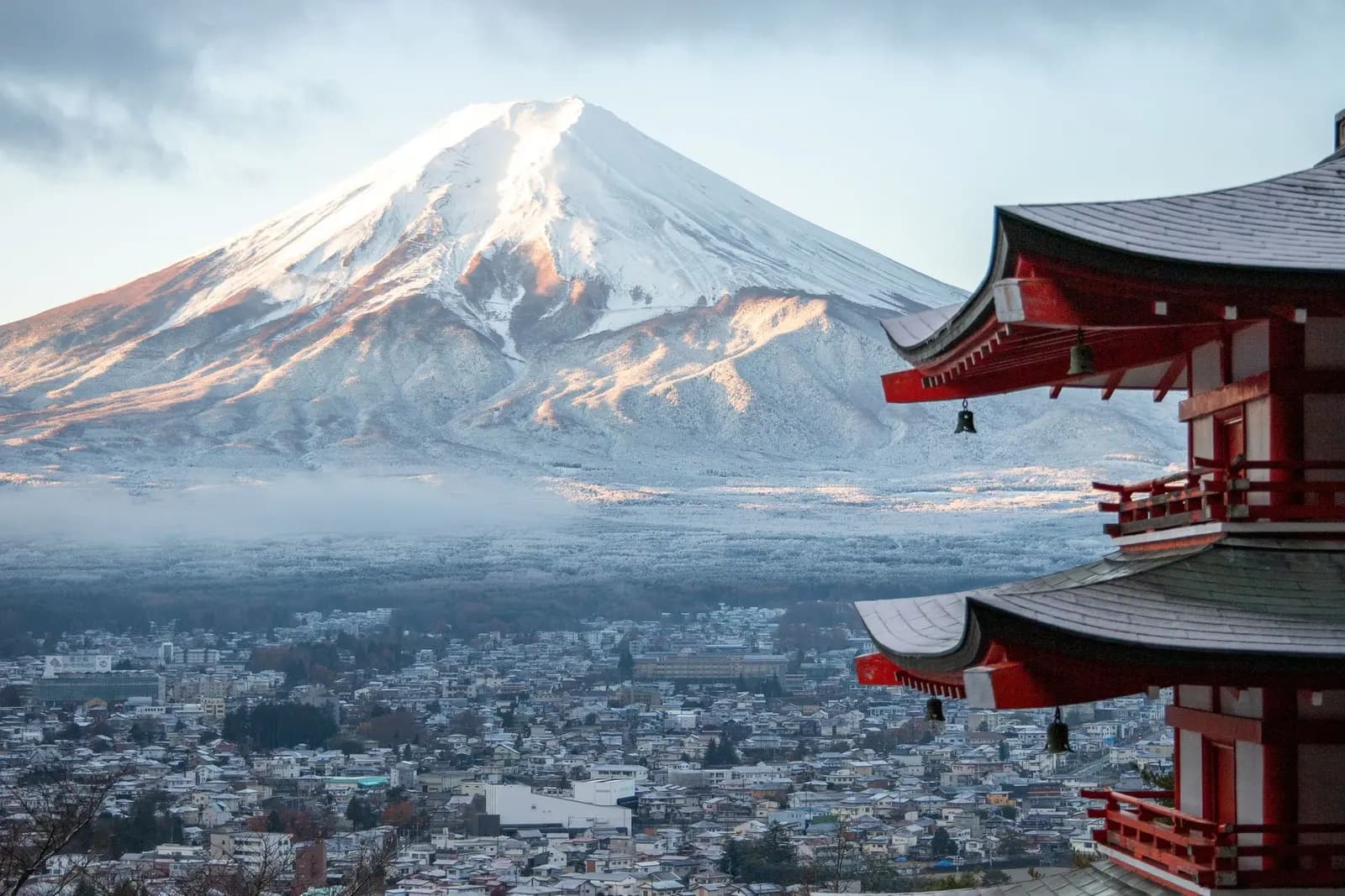 Snow-capped Mount Fuji behind the red Chureito Pagoda in Fujiyoshida